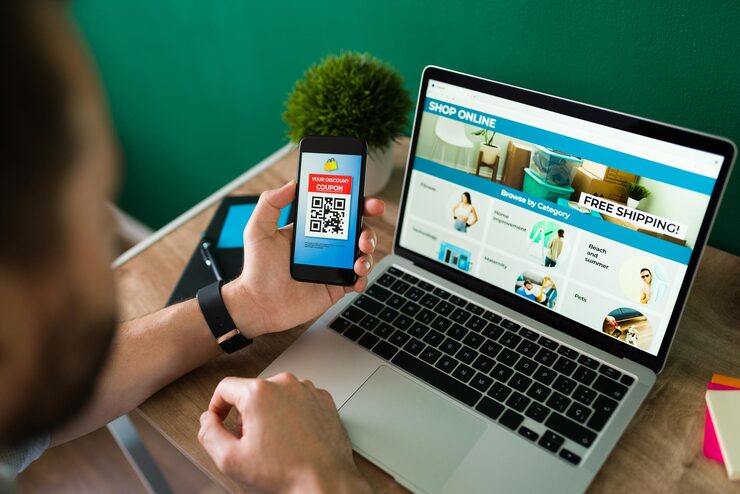 Persona che fa acquisti online con laptop e telefono - Giorgia Scribano